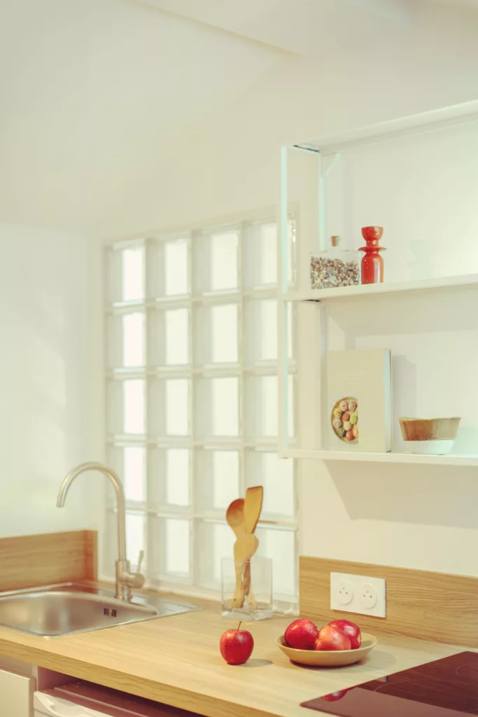 Le pavé de verre est idéal pour travailler les jeux de lumière. Ici il crée un second jour pour la salle de bain et apporte un touche rétro dans cette cuisine.